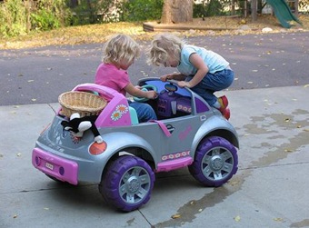 Crianças dirigindo um carro de brinquedo